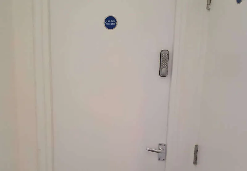 Completed white fire door with closer and access hardware